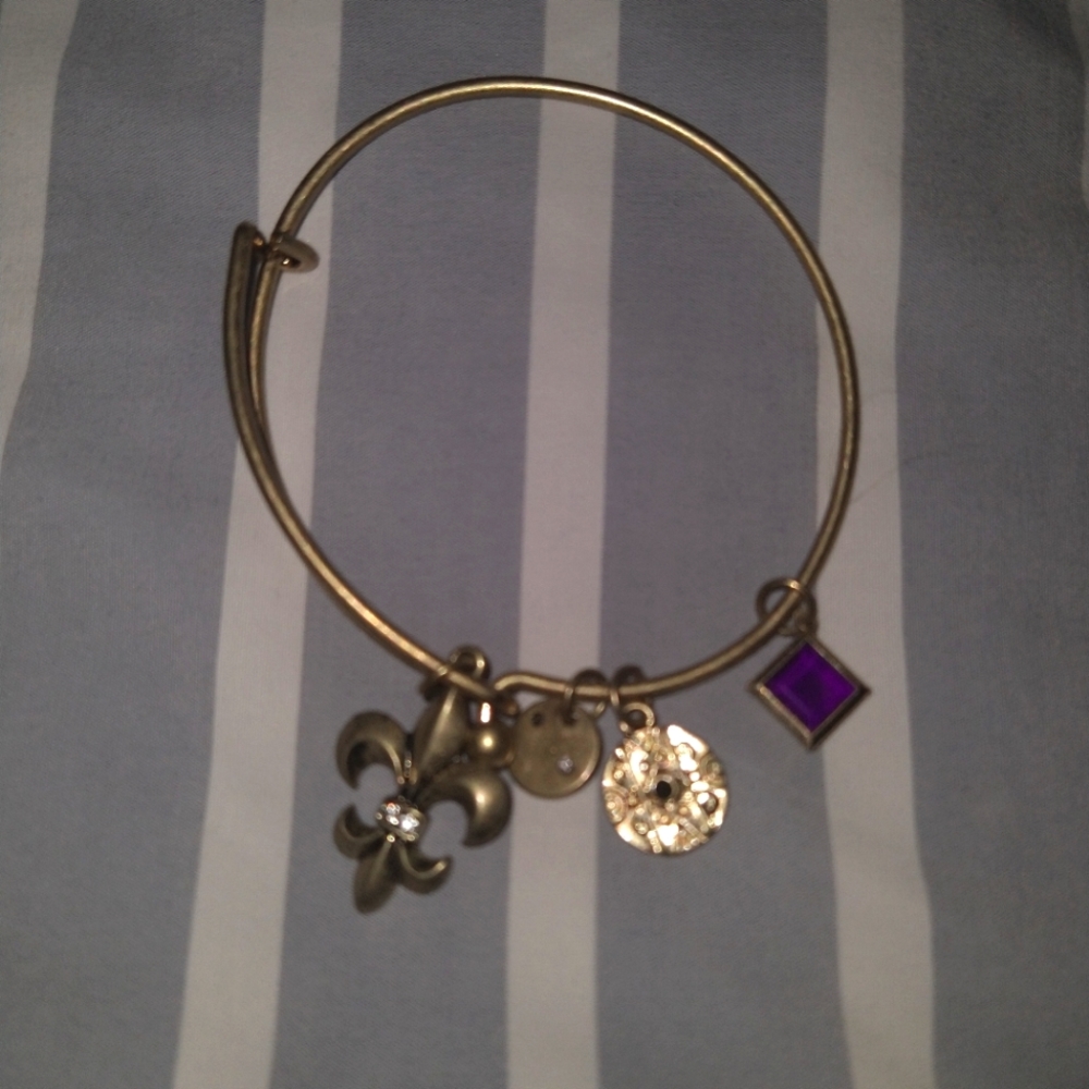 Gold bracelet with purple emblem and charms